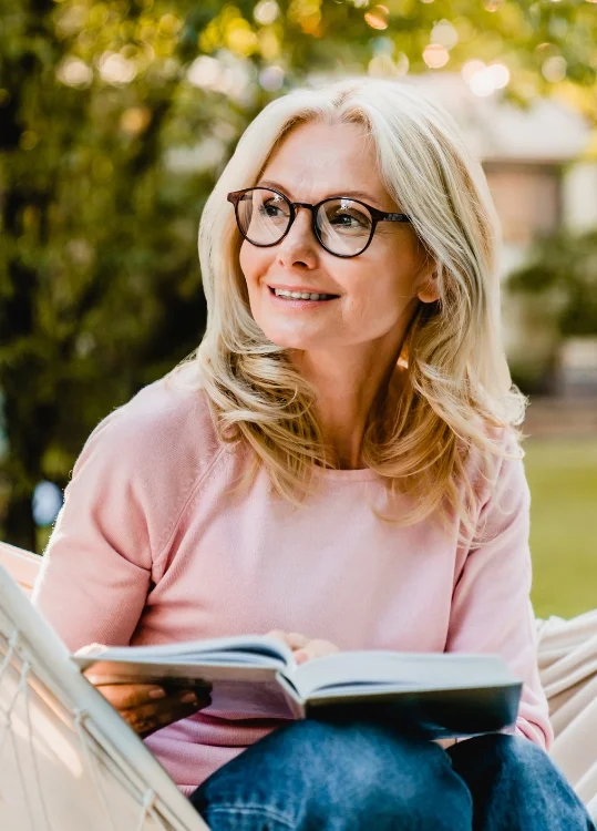 senior resident reading outdoors at Beacon Hill