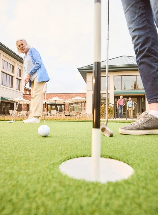 senior friends playing a round of golf outside at Beacon Hill Senior Living Community