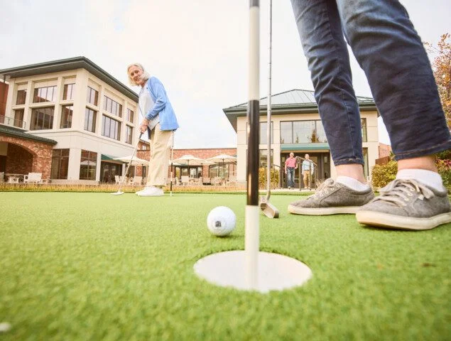 senior friends playing a round of golf outside at Beacon Hill Senior Living Community