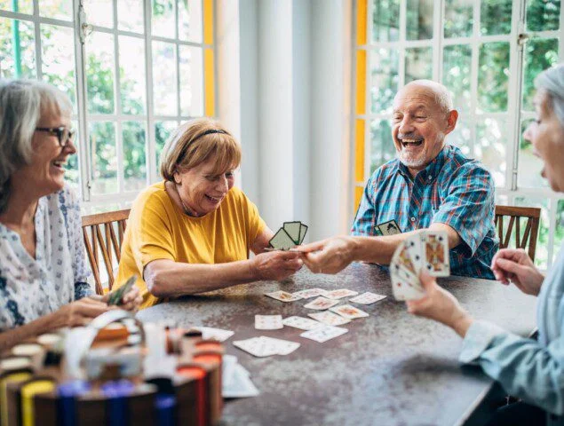 group of senior friends play cards together