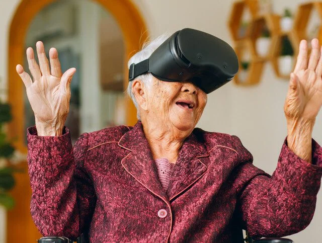 Asian old senior wearing vr headset feeling excited with metaverse. Retirement and senior lifestyle at home