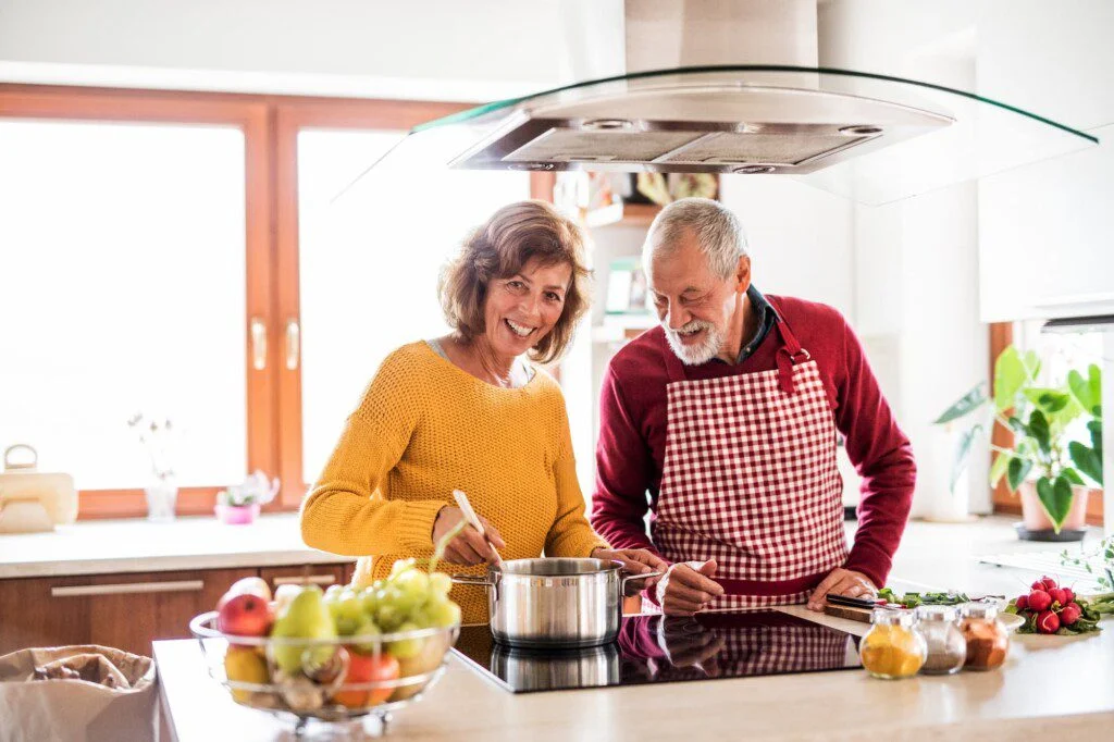 A senior man and senior woman cooking together nutritious recipes