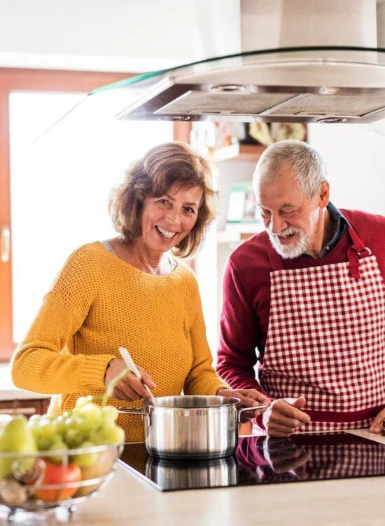 A senior man and senior woman cooking together nutritious recipes
