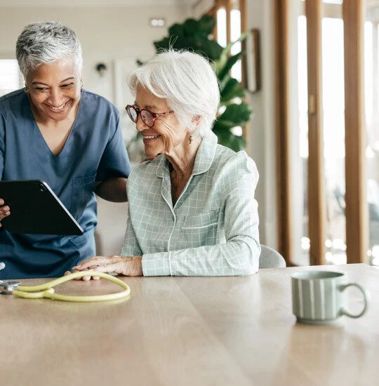 A compassionate nurse helping an elderly woman understand her healthcare options at home.