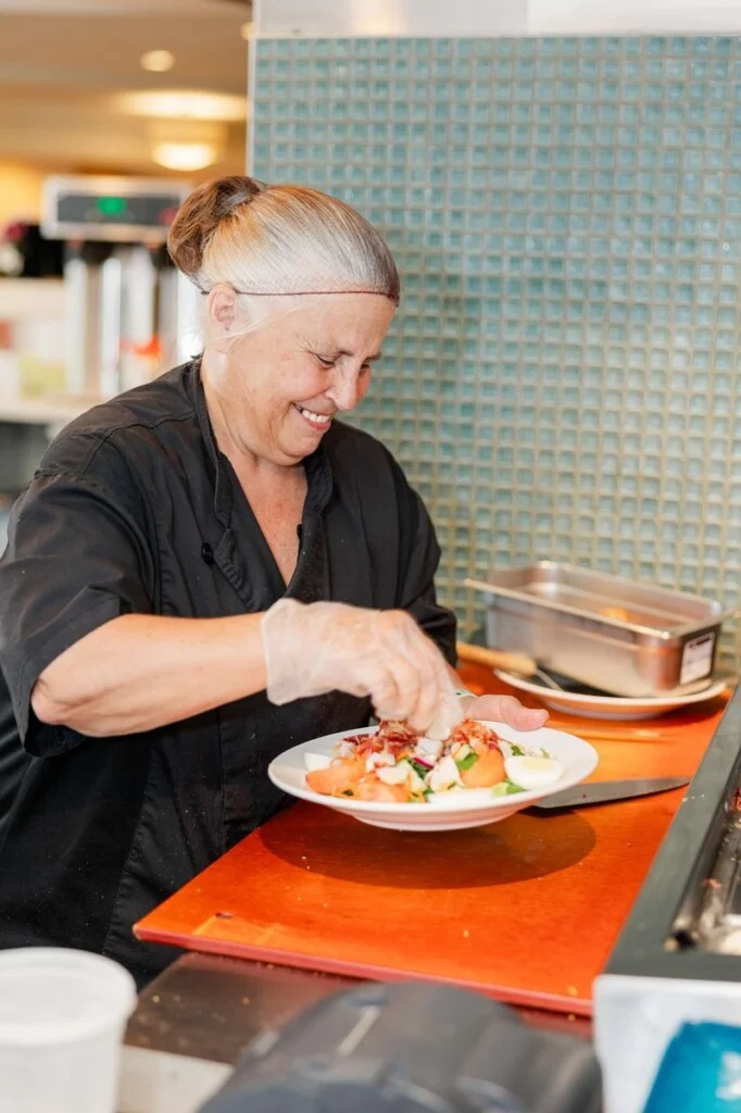 Cafe Chef Cherie Gutbrod plating a salad at Beacon Hill in Lombard, Illinois