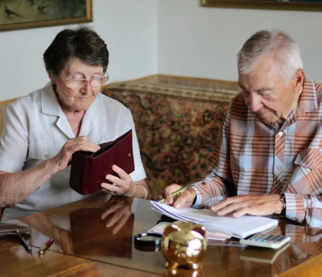 a senior couple review their finances in preparation for moving into senior living