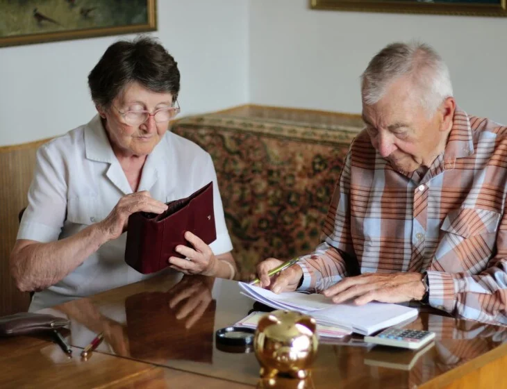 a senior couple review their finances in preparation for moving into senior living