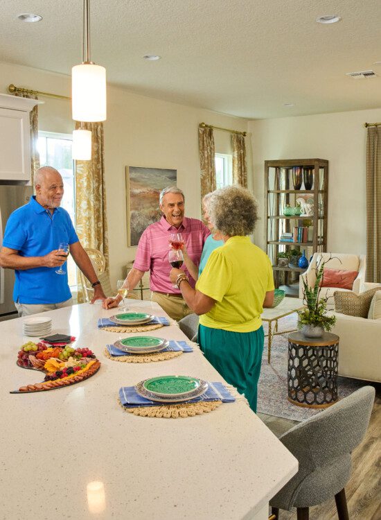 group of seniors gather in a villa home for snacks, drinks, and games