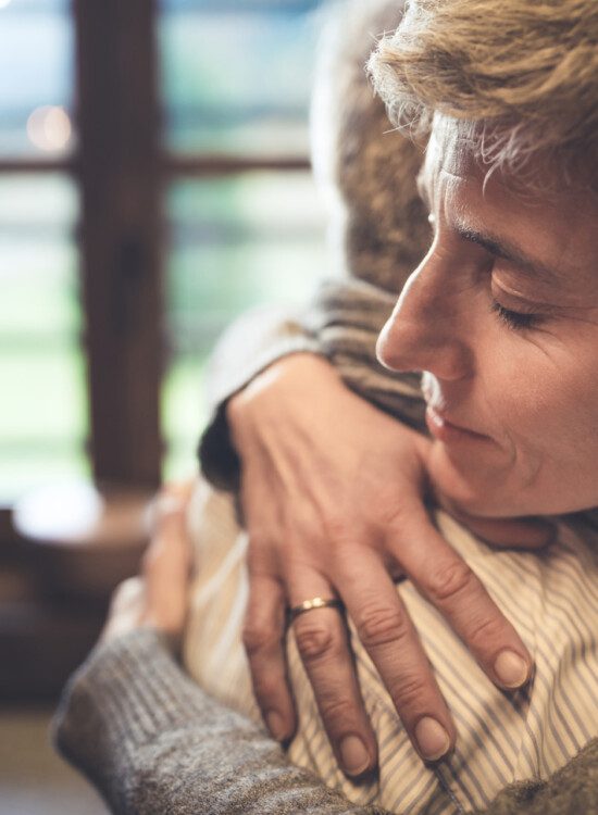 two seniors embrace in an emotional, heartfelt hug