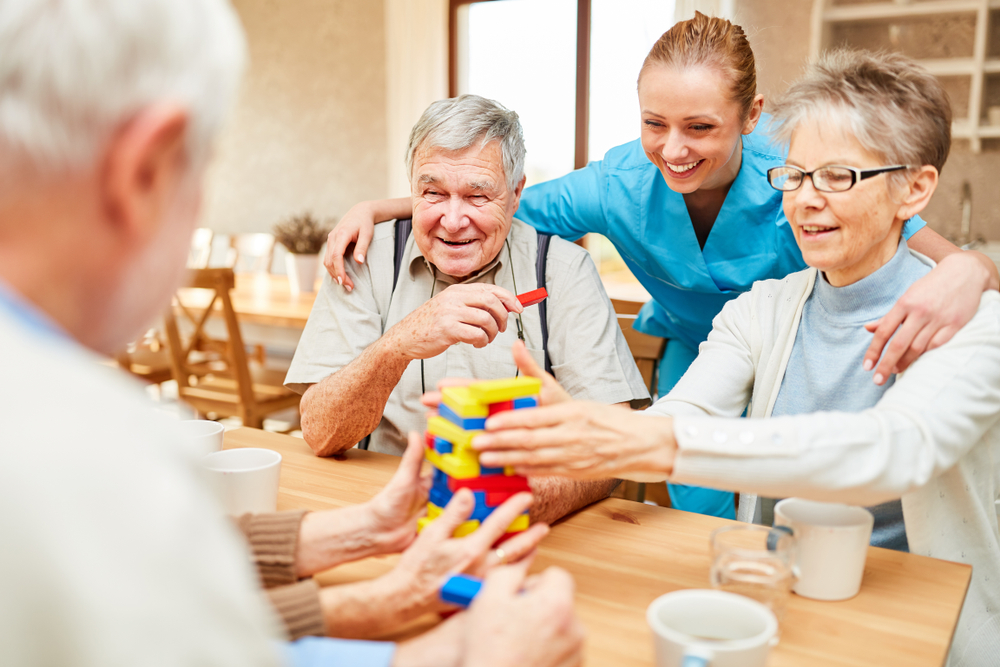 Group of seniors and a nurse playing games together