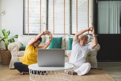 senior couple practicing yoga while sitting on their carpet