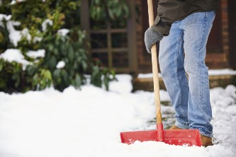 close-up of senior man shoveling the walkway of his home