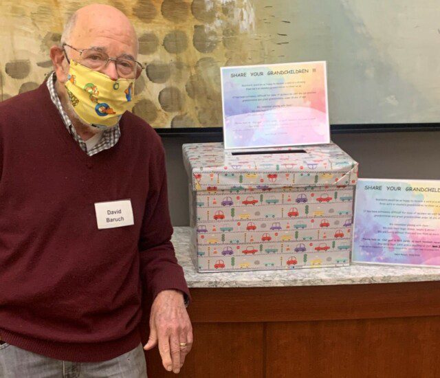 senior living resident stands by a box of uplifting greeting cards from others during the pandemic
