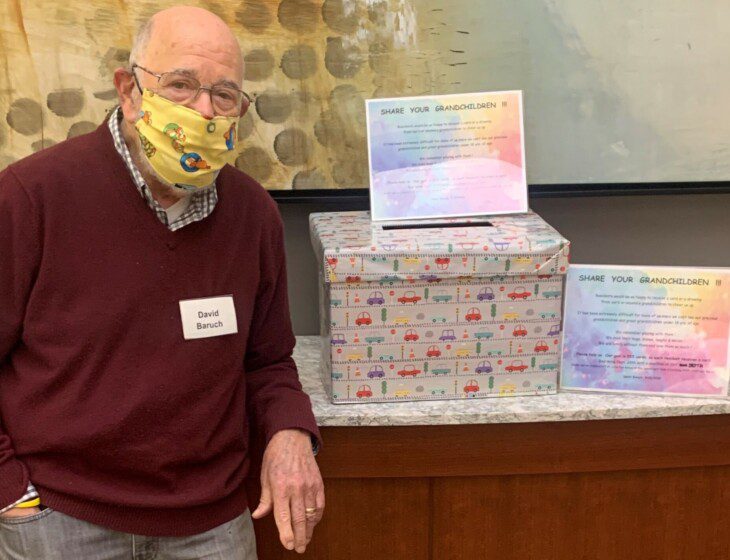 senior living resident stands by a box of uplifting greeting cards from others during the pandemic