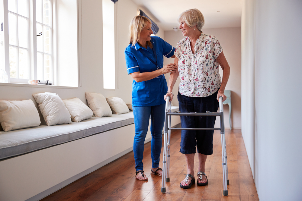 Nurse helping senior woman with a walker