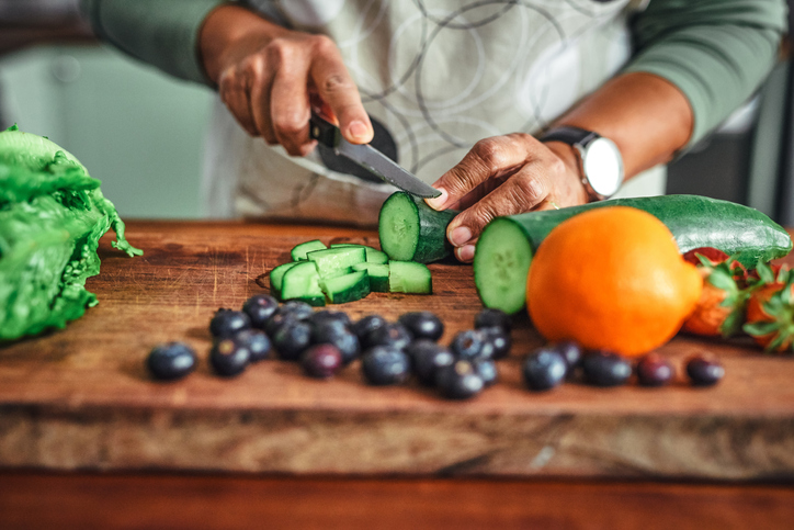 close-up of older woman chopping vegetables for a meal