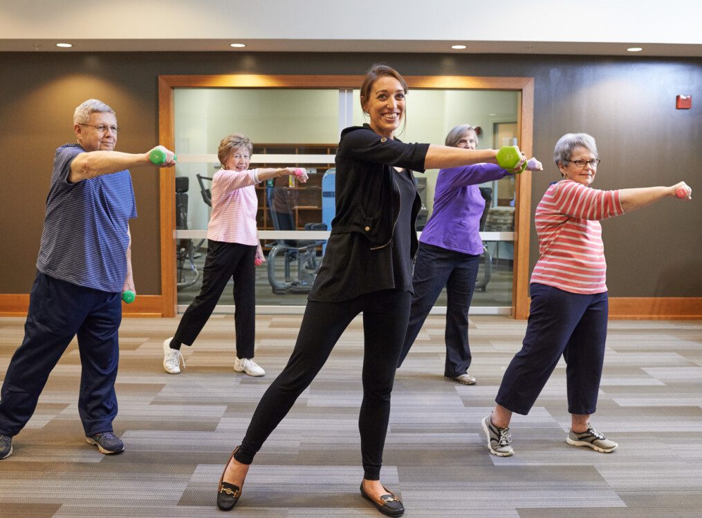 group of senior women use dumbbells for strength during cardio class at their senior living community