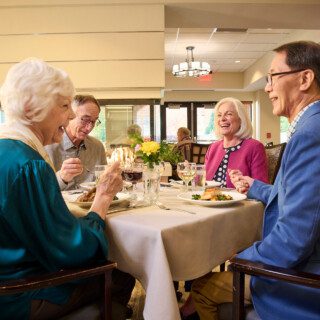 group of well-dressed senior friends enjoying a meal together in an elegant setting