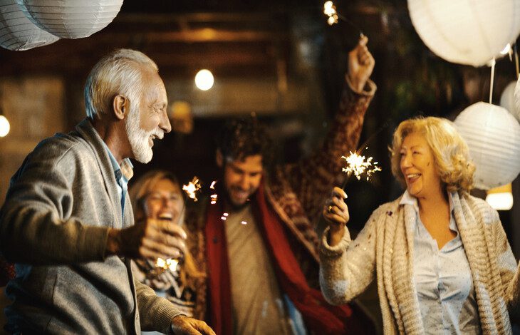 senior couple dances with sparklers under paper lanterns during a celebration