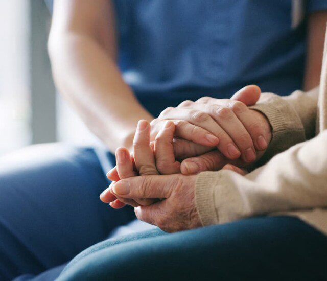 close-up of senior holding hands with their caregiver