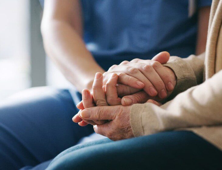 close-up of senior holding hands with their caregiver