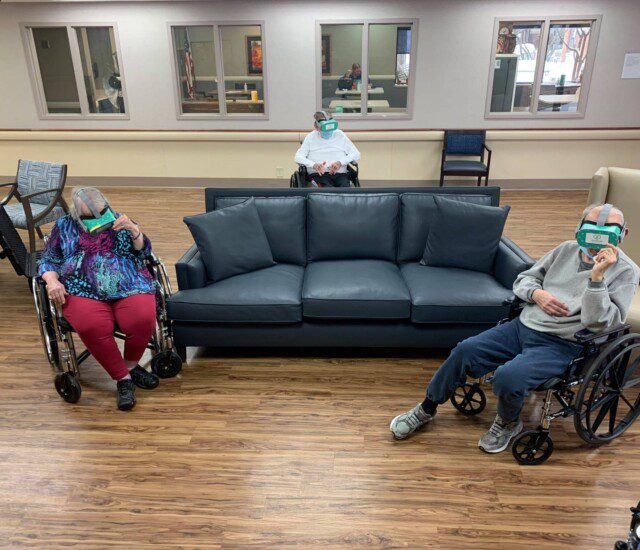 group of seniors in wheel chairs wear virtual reality headsets
