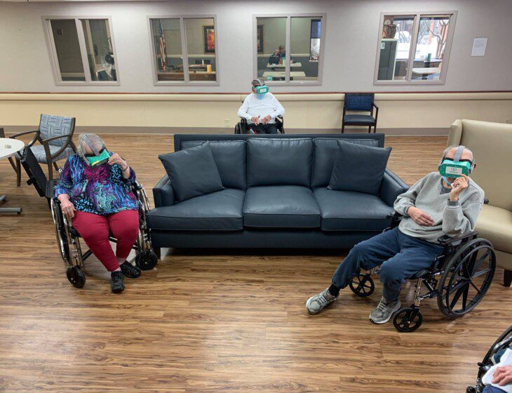 group of seniors in wheel chairs wear virtual reality headsets