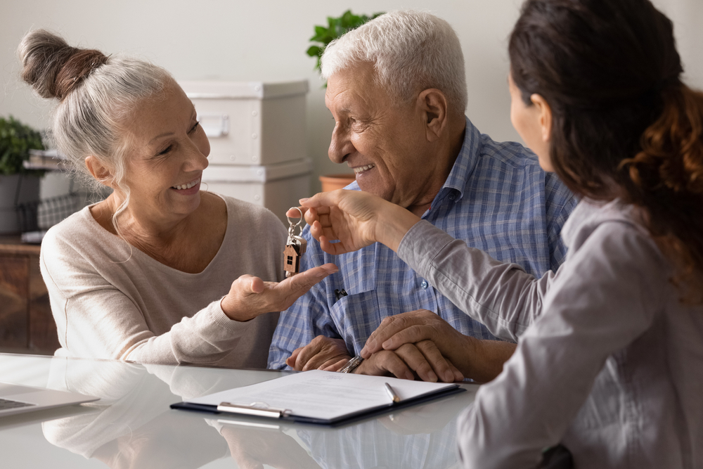 Senior couple receiving keys to their new home