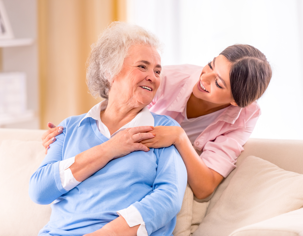 Nurse and senior woman holding each other