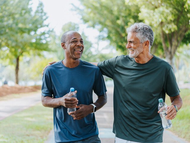 Senior friends walking in public park