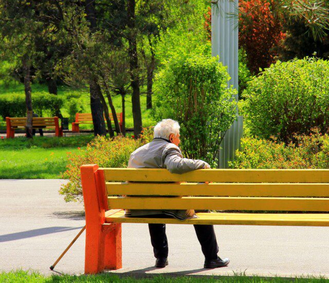 Senior man enjoying a park bench at the outdoor campus of Beacon Hill